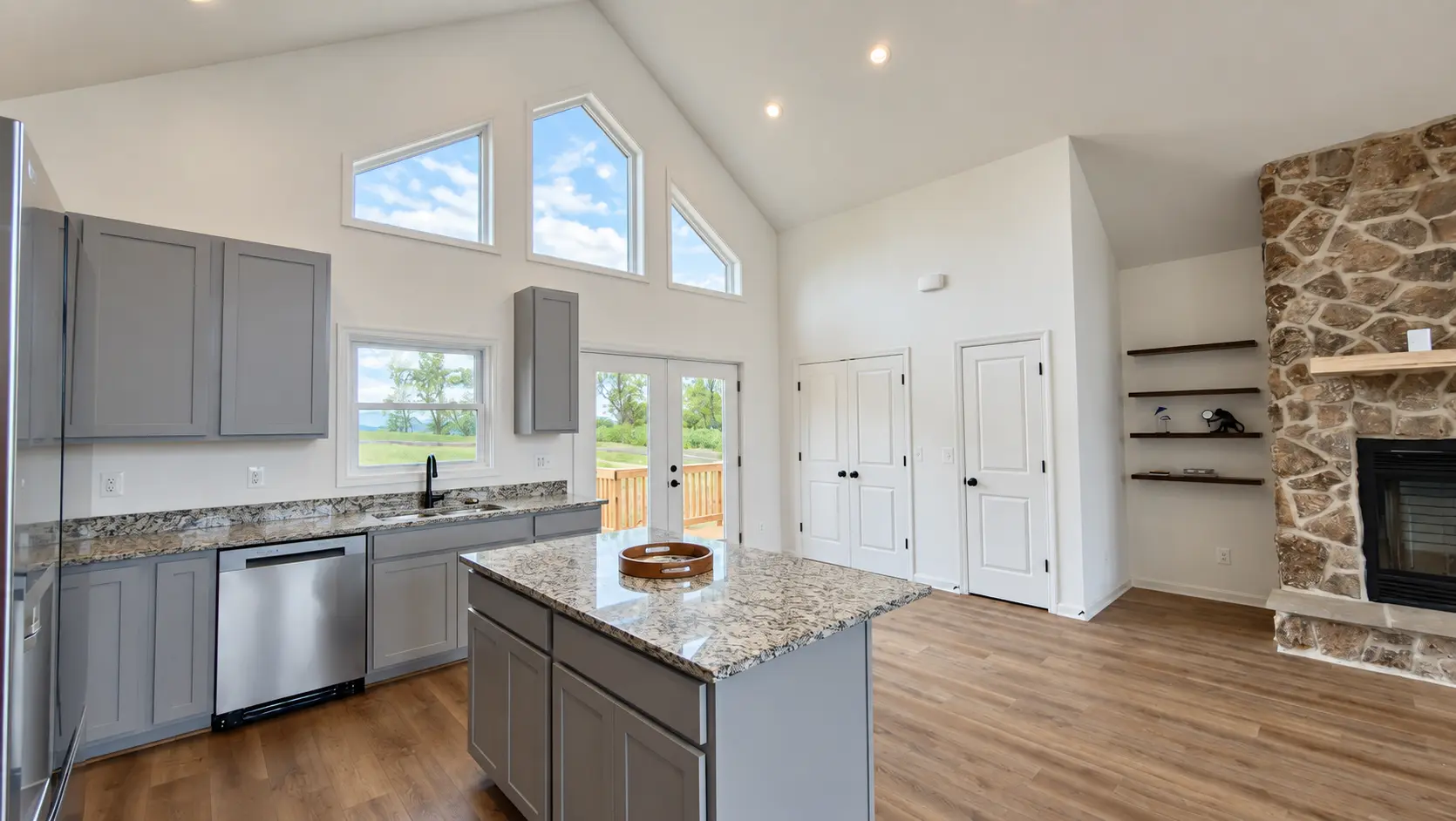 Grace Chalet kitchen island with the stone fireplace beyond